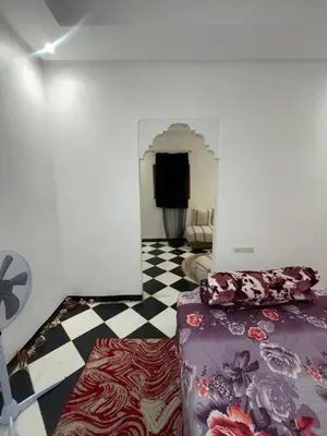 a room with a bed and a checkered floor at Mini Studio in Marrakech
