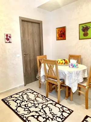 a dining room with a table and chairs with a bowl of fruit at Appartement Marrakech in Marrakech