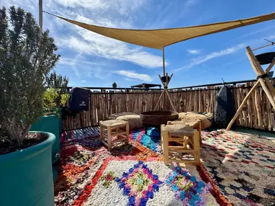 a patio with a table and chairs on a rug at Riad Dar Najwa in Marrakech