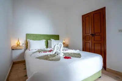 a bedroom with a white bed with towels on it at Riad Ilyan & Spa in Marrakech