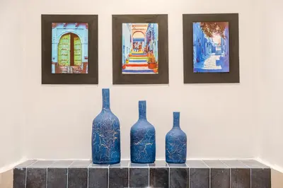 four blue vases sitting on a counter in front of paintings at Maison 3 chambre avec bassin chauffée centre ville Gueliz in Marrakech