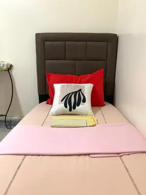 a pink bed with a black and white pillow on it at Steps from Airport only 5 minutes ,Ideal for Travelers in Marrakech