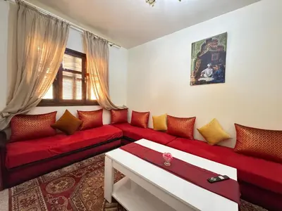 a living room with a red couch and a window at Steps from Airport only 5 minutes ,Ideal for Travelers in Marrakech