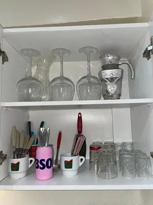 a shelf filled with glasses and mugs and utensils at Steps from Airport only 5 minutes ,Ideal for Travelers in Marrakech