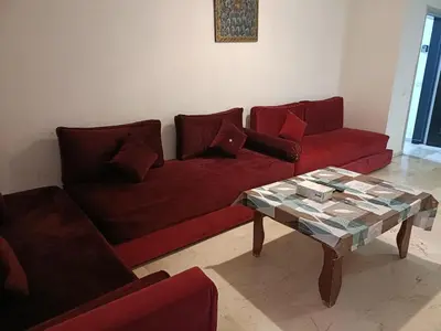 a living room with a red couch and a table at family apartment 06 in Marrakech