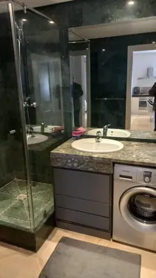 a bathroom with a sink and a washing machine at Appartement centre Marrakech in Marrakech