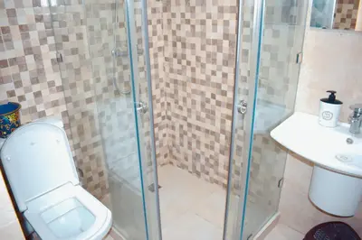 a bathroom with a shower with a toilet and a sink at Appartement Marrakech in Marrakech