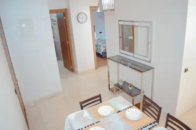 a dining room with a table and chairs and a clock at Appartement Marrakech in Marrakech