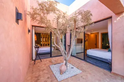a bedroom with a bed and a tree in a vase at Villa Nomade - 4 BR BA - Piscine - Parking - Ourika in Sraghna