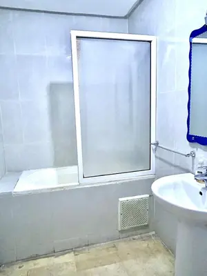 a bathroom with a window and a tub and a sink at imm O Family apartment 7 in Marrakech