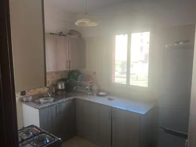a kitchen with a counter and a window in it at Appartement a côté Aéroport Menara marrakech in Marrakech