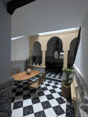 a room with a table and a black and white checkered floor at Almohafidon room in Marrakech