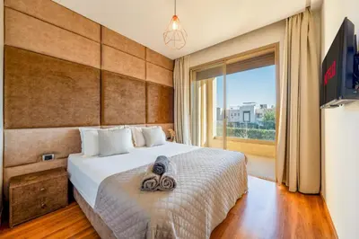 a bedroom with a bed and a large window at 2-Bedroom Residence Jubeae - Pool & Golf Nearby in Marrakech