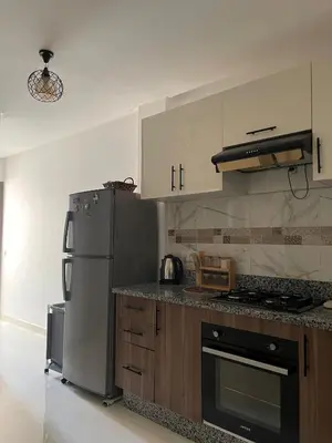 a kitchen with a stainless steel refrigerator and cabinets at Home Star Luxury Apartment Marrakech in Marrakech