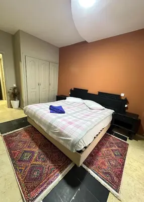 a bedroom with a large bed with two rugs at apartment 9 imm O in Marrakech