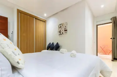 a bedroom with a white bed with two clocks on it at Marrakech Haven Appartement Familial Wifi HD IPTV Netflix in Marrakech