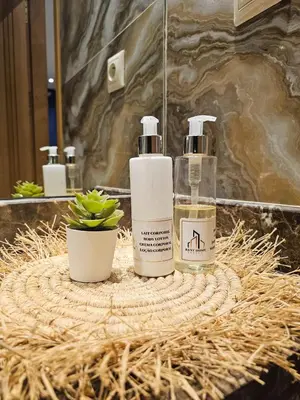 two bottles ofodorizers sitting on a wicker table in a bathroom at Oasis - 7 min from Majorelle - Medina and Nightlife with AC and Pool in Marrakech