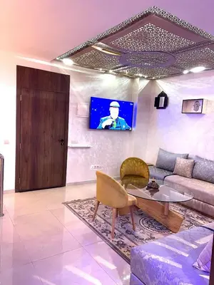 a living room with a couch and a table and a tv at Duplex Luxury Appartement in Marrakech