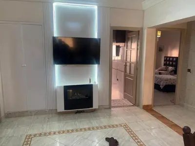 a living room with a fireplace and a flat screen tv at Bel appartement au relaxer in Marrakech