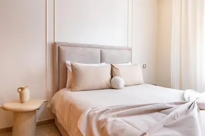 a white bedroom with a large bed with white pillows at Downtown Gueliz Modern 1BR AC, Fast WIFI , Parking in Marrakech
