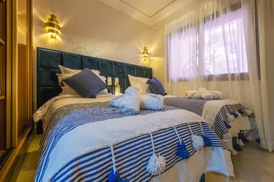 a bedroom with two beds with towels on them at Appartement Bien équipé au Centre ville Garage Privé et Climatiseur Fibre 5G in Marrakech