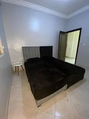 a bedroom with a large black bed and a chair at Appartement bros in Marrakech