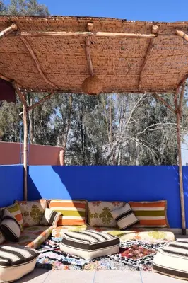 a patio with a couch and a blue wall at Maison Marrakech in Touggana