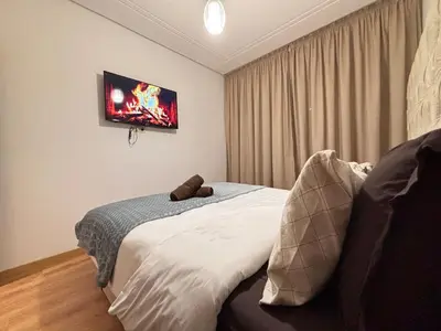 a bedroom with a bed and a tv on the wall at The Cristal House in Marrakech
