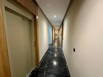 a hallway with black marble flooring in a building at Petit paradis près du centre in Marrakech