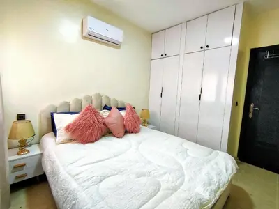 a bedroom with a white bed with pink pillows at Chic & Comfort Apartment in Marrakech