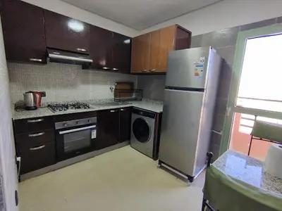 a kitchen with a stainless steel refrigerator and a dishwasher at Chic & Comfort Apartment in Marrakech