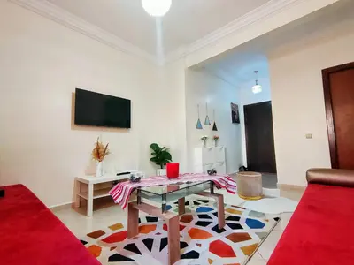 a living room with a table and a tv at Stylish & Bright Apartment in Marrakech