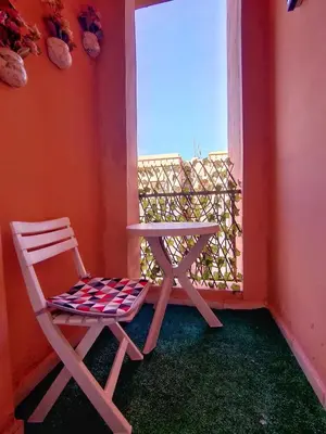 a white chair sitting next to a window at Stylish & Bright Apartment in Marrakech