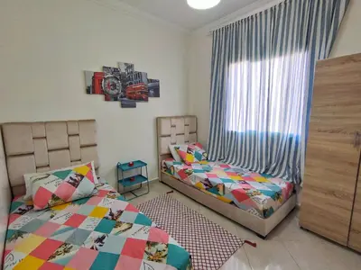 a bedroom with two twin beds and a window at Stylish & Bright Apartment in Marrakech