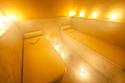 a bathroom with a toilet and two lights on the wall at Riad La Villa Marrakech in Marrakech