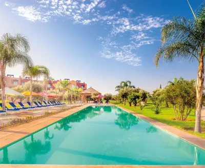 a swimming pool in a resort with palm trees at Luxurious Apartment in Marrakech in Dar Caïd Layadi