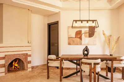 a dining room with a table and a fireplace at Cozy & Stylish Apartment in Marrakech in Marrakech