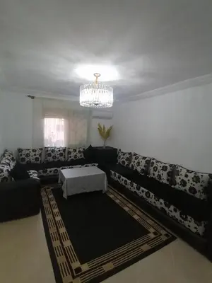 a living room with a couch and a chandelier at Appartement cosy in Marrakech