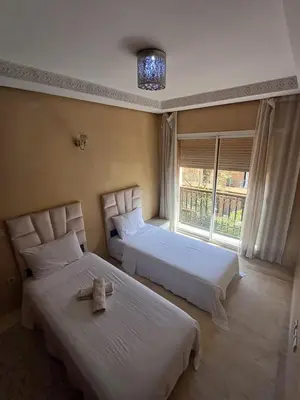 a bedroom with two beds and a window at Appartement familial résidence Hamza 2 chambres in Marrakech