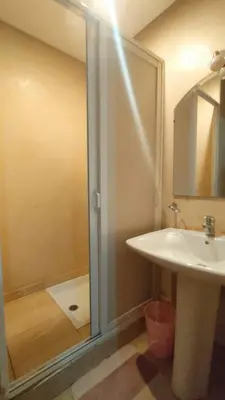 a bathroom with a shower and a white sink at Appartement familial résidence Hamza 2 chambres in Marrakech