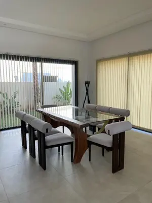 a dining room with a glass table and chairs at Villa Rana in Marrakech