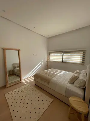 a bedroom with a large bed and a mirror at Villa Rana in Marrakech