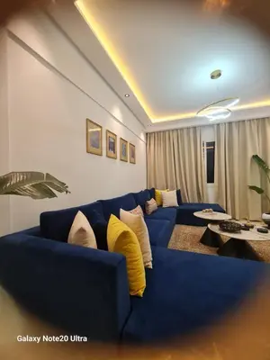 a living room with a blue couch with yellow pillows at Quiet studio in Marrakech