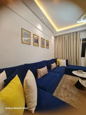 a blue couch with pillows in a living room at Quiet studio in Marrakech