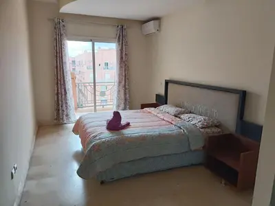 a bedroom with a bed with a cat sitting on it at family apartment 34 in Marrakech