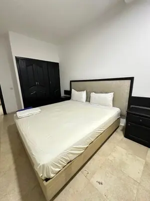 a bedroom with a large bed with white sheets at family apartment 32 in Marrakech