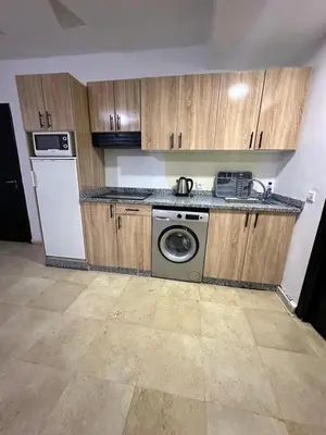 a kitchen with wooden cabinets and a washer and dryer at family apartment 32 in Marrakech