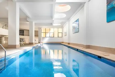 a large swimming pool with blue water in a building at Résidence Miramas 2 Cosy Appartment 2 in Marrakech