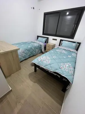 a bedroom with two beds and a desk and avertisement at Appartement 2 chombr salon a marrakech in Marrakech