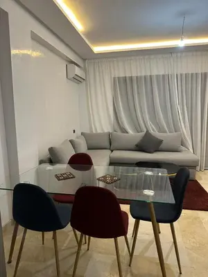 a living room with a couch and a glass table at Appartement a gueliz Marrakech in Marrakech